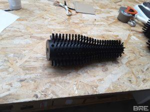 Brosse rotative cylindrique avec garnissage de forme spécifique conçue pour le nettoyage des bouteilles dans le secteur viticole.