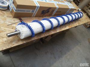 Brosse rotative cylindrique avec garnissage en hélice pour le convoyage et le brossage des graines de haricot.