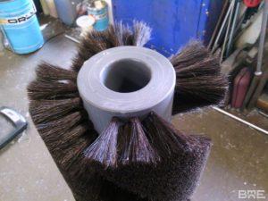 Une brosse rotative avec garnissage souple en hélice est présentée. Cette brosse est conçue pour le lustrage des pommes et offre une finition lisse et uniforme.