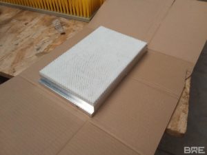 Une brosse plate avec des poils en polypropylène, fixés sur un support en aluminium, conçue pour le convoyage de produits dans l'industrie pharmaceutique.
