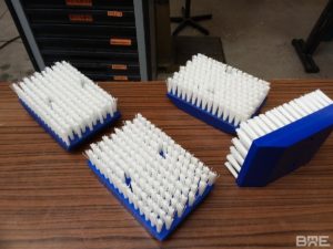 brosses plates modulaires sur mesure, conçues pour le brossage des meules de fromage dans l'industrie fromagère.