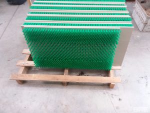 La brosse est constituée de plaques en plastique garnies de fibres synthétiques souples. Les plaques sont fixées à la rampe et s'adaptent à sa forme, offrant une surface rugueuse et sûre pour les anguilles.