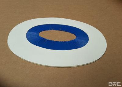 Brosse guide utilisée pour guider et emboîter des boîtes de fromage dans une chaîne de production. La brosse assure un mouvement fluide et précis des boîtes, minimisant les dommages et les erreurs d'alignement.